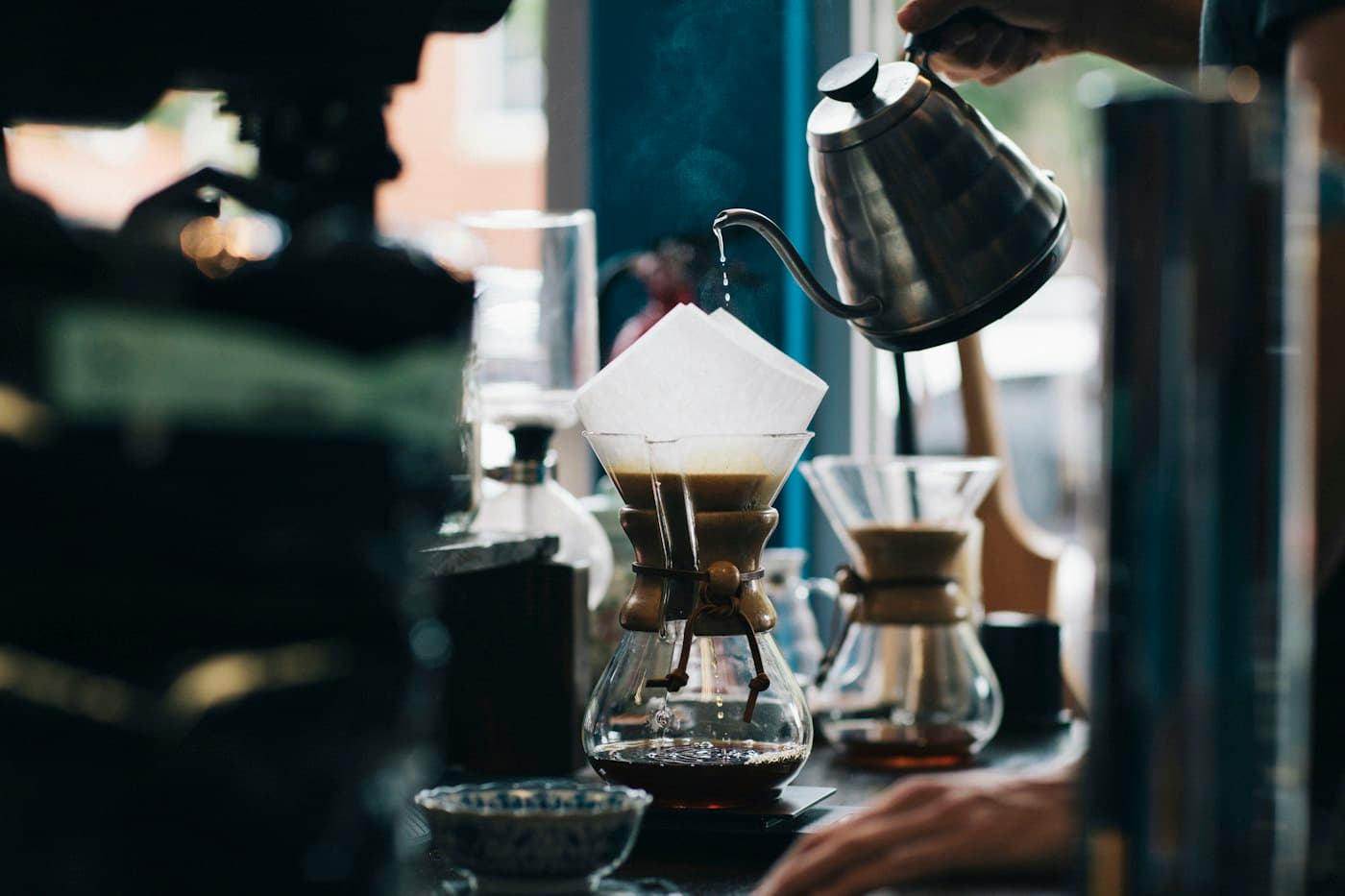 Barista slowly pouring water over a pour-over coffee